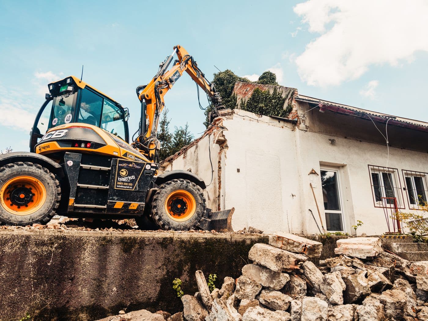 Excavator tearing down a single-story house